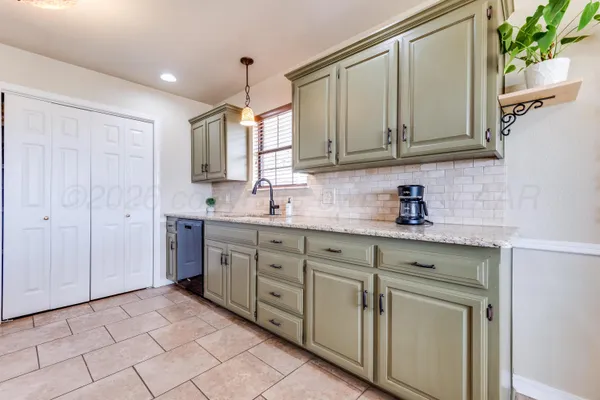 a kitchen with white cabinets a sink and dishwasher