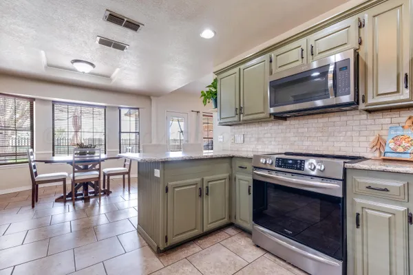 a kitchen with a stove top oven microwave and cabinets
