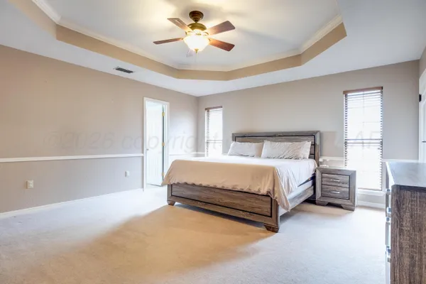 a spacious bedroom with a bed and a chandelier
