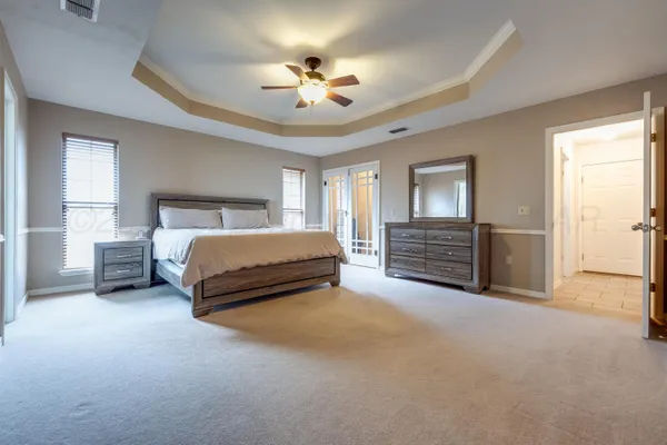 a spacious bedroom with a bed and a chandelier