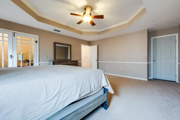 a bedroom with a large bed and a chandelier
