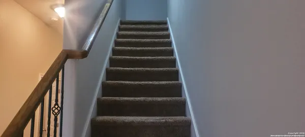 a view of staircase with wooden floor and white walls