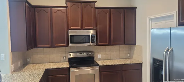 a kitchen with stainless steel appliances granite countertop a refrigerator stove and microwave