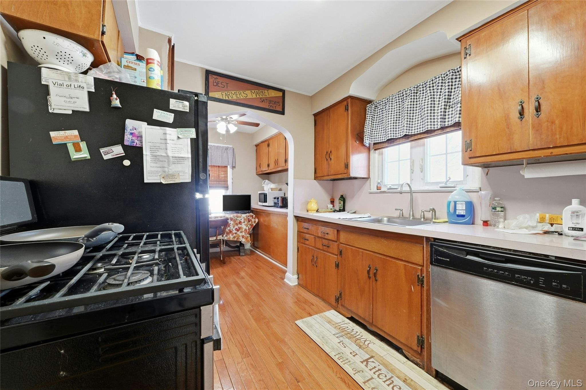 197 Foxhurst Road Oceanside, NY 11572 - Photo 13 of 28 The Cabinet Lined Kitchen Offers Original Solid Wood Cabinetry, A Large Window Over The Sink For Natural Light With A Charming Archway, Hardwood Floors & Another Charming Archway Into The Dinette Area.