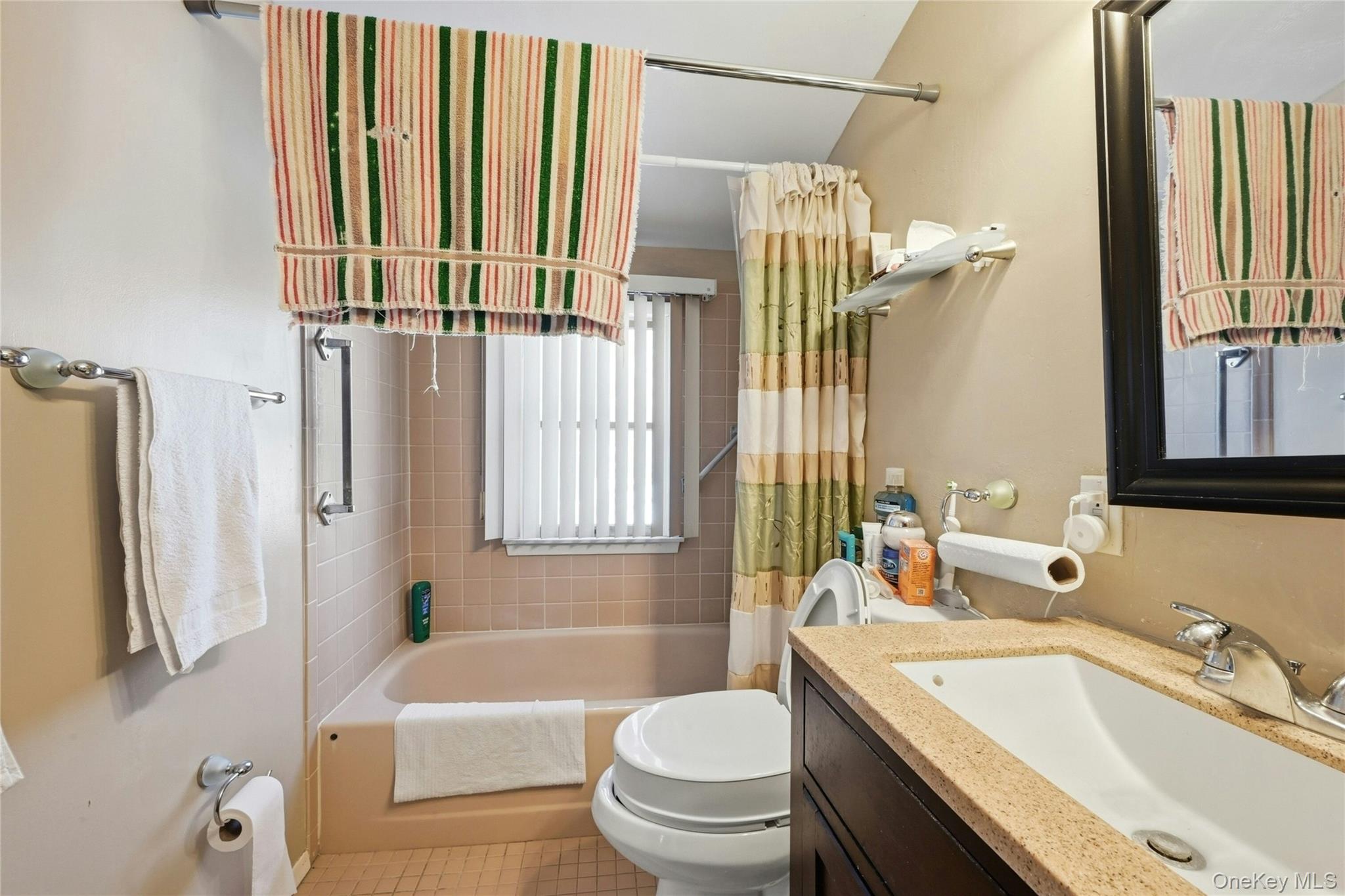 197 Foxhurst Road Oceanside, NY 11572 - Photo 23 of 28 Another View Of The Lovely Second Floor Bathroom Offering A Stone Topped Vanity, Fully Ceramic Tiled Walls/Tub Surround, Large Window For Natural Light, And A Ceramic Tiled Floor.