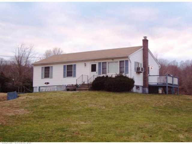 a view of a house with a big yard and large trees