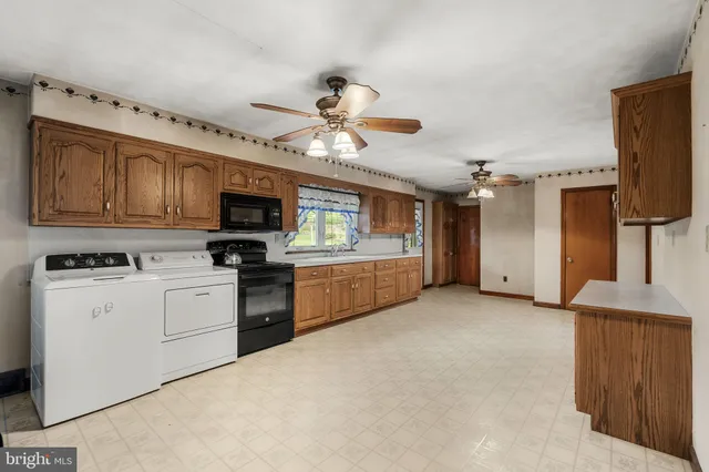 a kitchen with stainless steel appliances granite countertop a refrigerator a stove top oven a sink and dishwasher