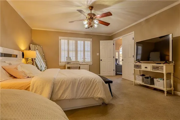 a bedroom with a bed and a flat tv screen on dresser