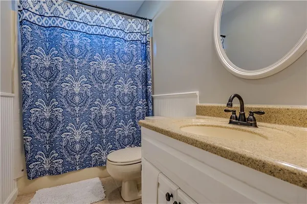 a bathroom with a granite countertop toilet and a sink