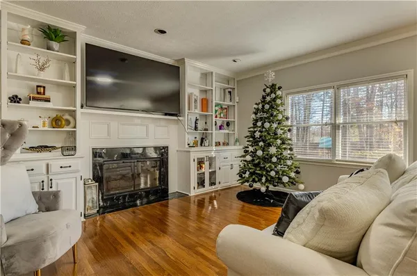 a living room with furniture a flat screen tv and a fireplace