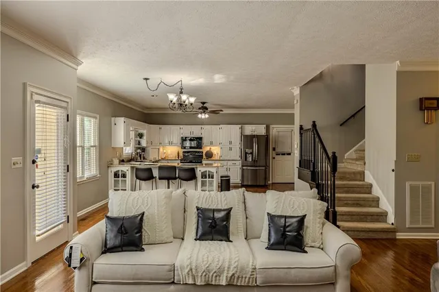 a living room with furniture and a chandelier