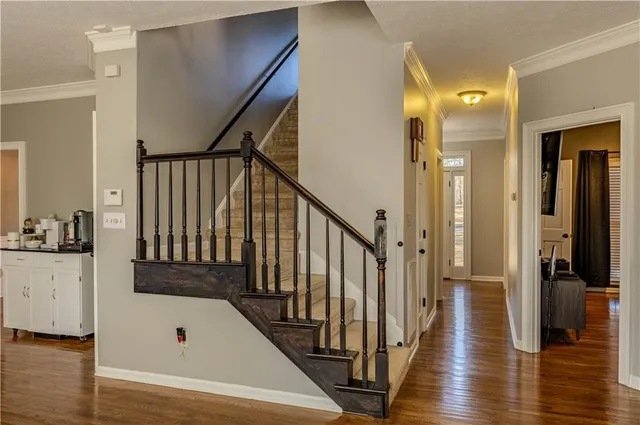 a view of a hallway with wooden floor and staircase