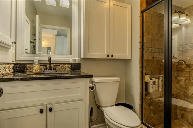 a bathroom with a granite countertop toilet sink and shower