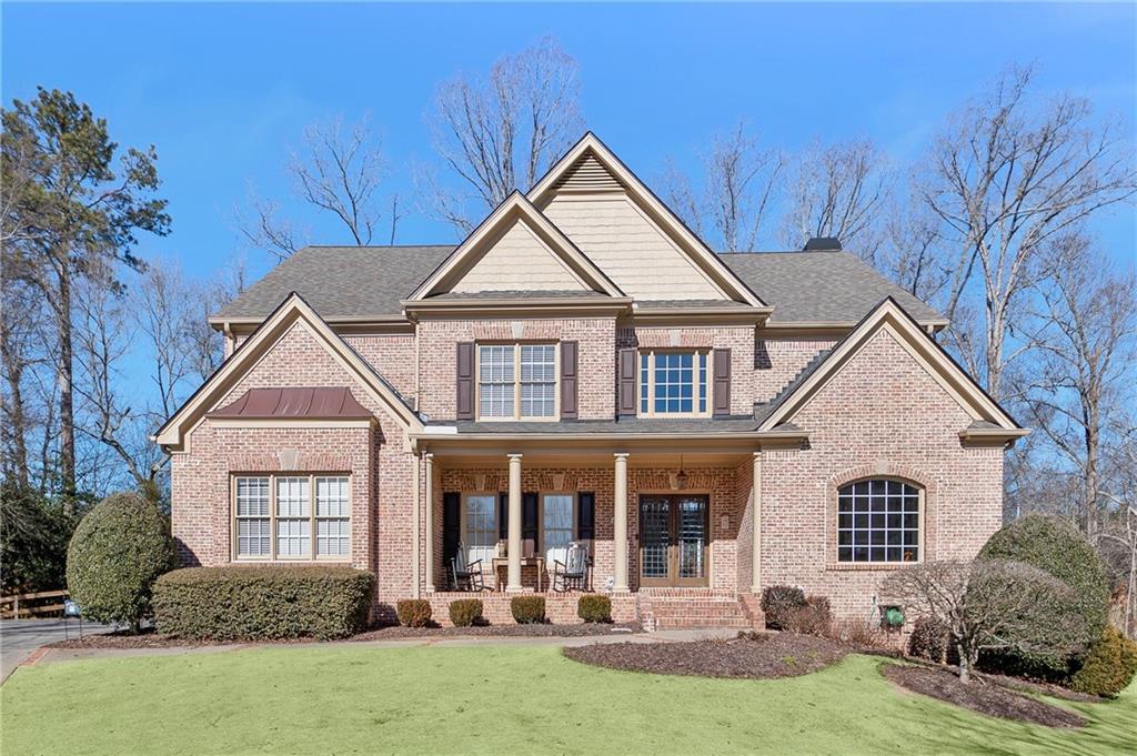 6885 Woodspring Way Cumming, GA 30040 - Photo 1 of 1 a front view of a house with a yard and garage