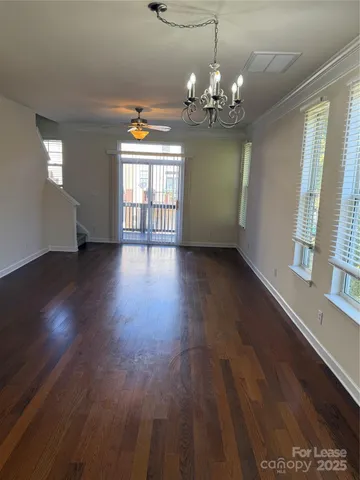 a hallway with wooden floor chandelier and entryway