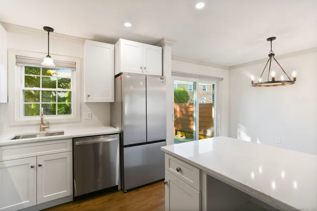 a kitchen with kitchen island a counter space a sink appliances and windows