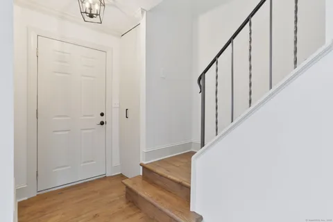 a view of staircase with white walls and white door