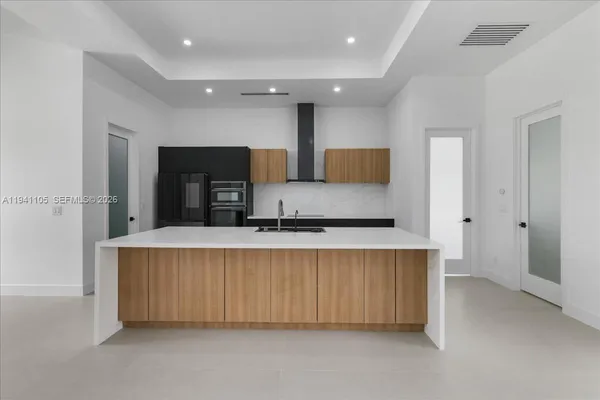a large kitchen with a large counter top stainless steel appliances and cabinets