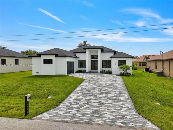 a front view of a house with a garden