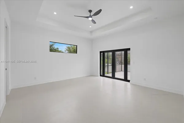 an empty room with windows and ceiling fan