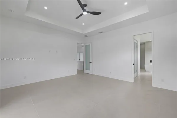 an empty room with a ceiling fan and window