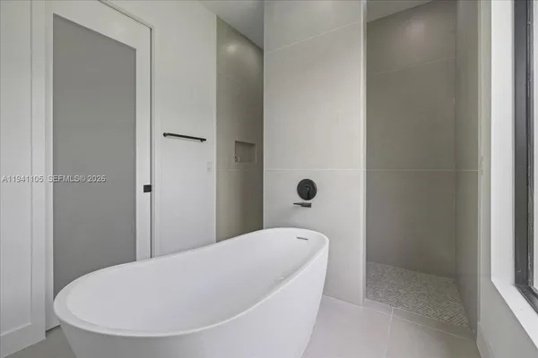 a bathroom with a tub and mirror