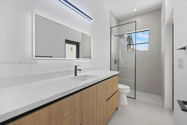 a bathroom with a sink a toilet and mirror