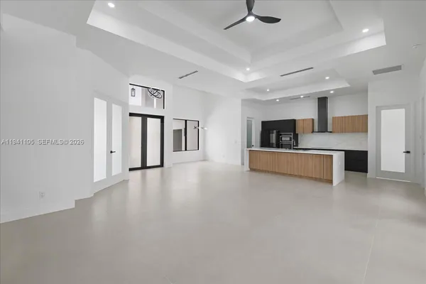 a view of a kitchen with a sink and dishwasher a kitchen island with wooden floor