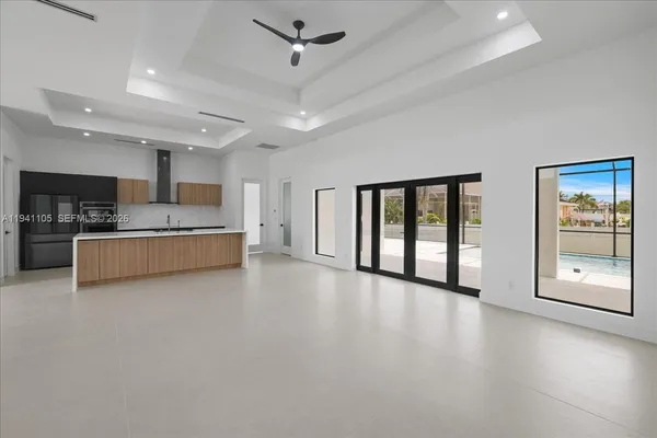 a big room with chandelier fan and windows