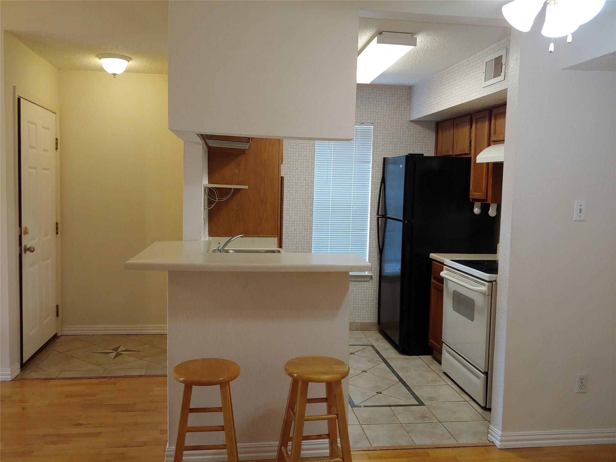 10555 Turtlewood Court, Unit 1511 Houston, TX 77072 - Photo 3 of 23 a kitchen with stainless steel appliances granite countertop a refrigerator and a stove