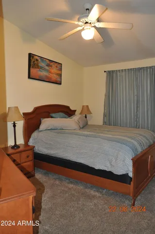 a bedroom with a bed couch and a mirror