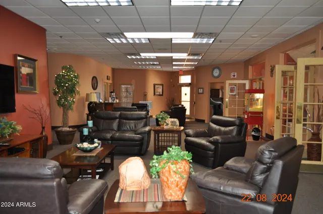 a view of a workspace room with furniture and a window
