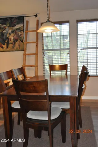 a view of a hallway to a livingroom with wooden floor and windows