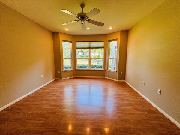 a view of an empty room with window and wooden floor