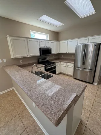 a kitchen with stainless steel appliances granite countertop a sink refrigerator and microwave