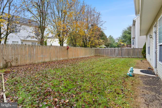 a view of backyard with wooden fence