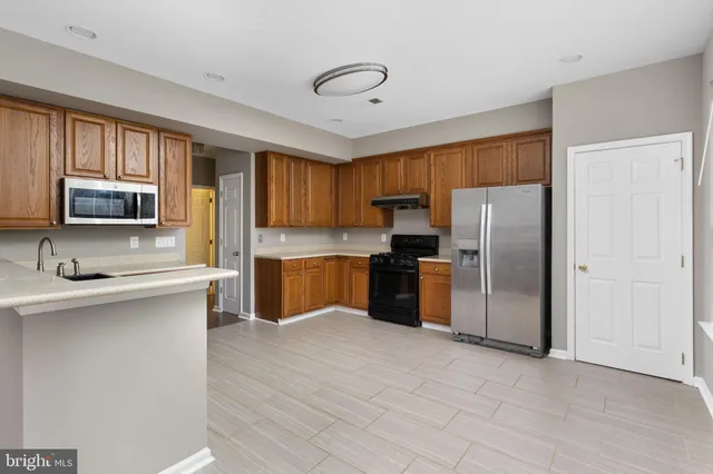 a kitchen with stainless steel appliances granite countertop a refrigerator sink and cabinets