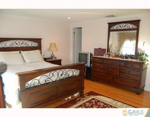 4406 Hana Road Edison, NJ 08817 - Photo 5 of 10 a bedroom with a bed and a dresser