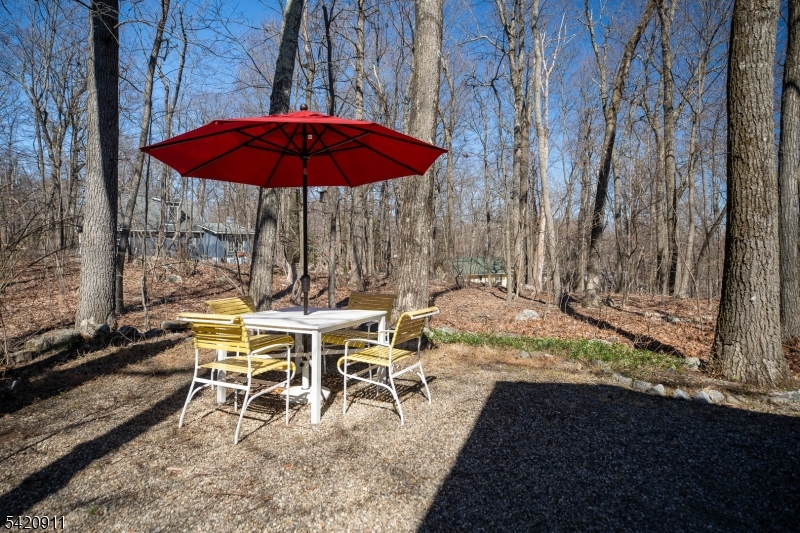 5 Anawa Road Vernon, NJ 07422 - Photo 31 of 44 a view of a patio with table and chairs under an umbrella with large trees