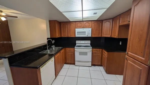a kitchen with granite countertop cabinets and black appliances