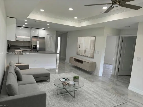a living room with furniture and kitchen view