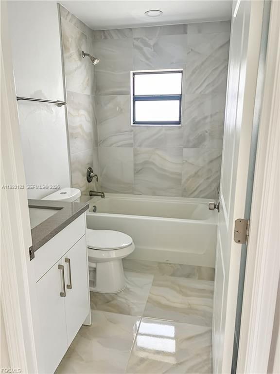 4854 30th Street Southwest, Unit 4854 Lehigh Acres, FL 33973 - Photo 8 of 11 a bathroom with a granite countertop sink toilet and shower
