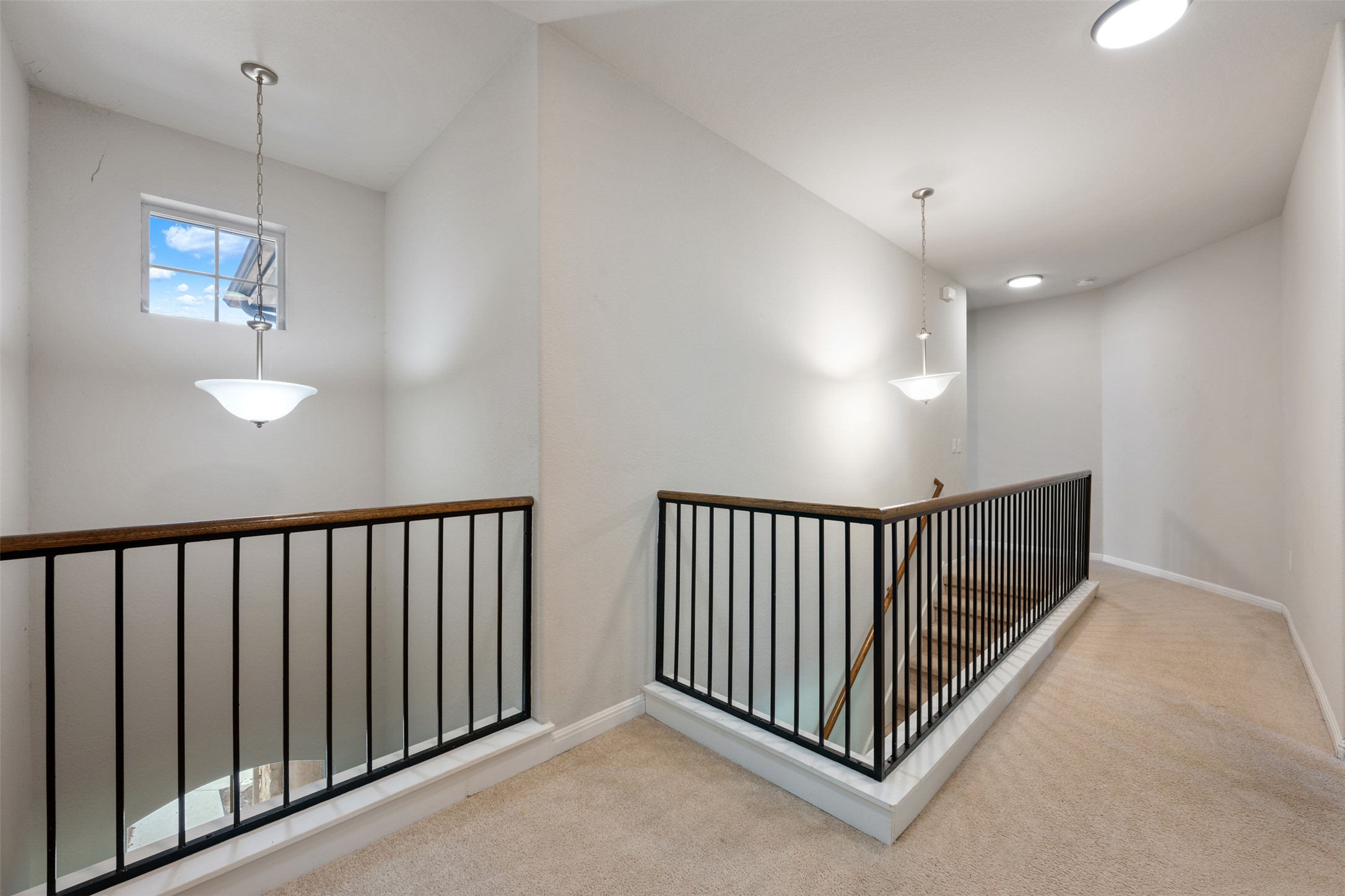 211 Parable Cove Pflugerville, TX 78660 - Photo 30 of 40 Upper-level landing featuring a window, two pendant light fixtures, recessed lighting, and carpeting