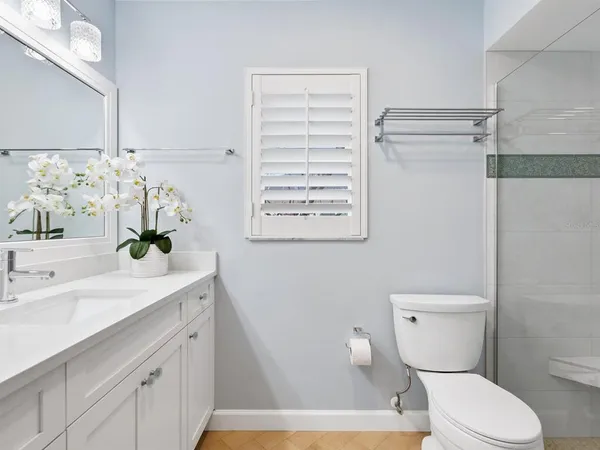 a bathroom with a sink a toilet and shower