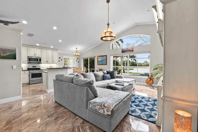 a living room with furniture kitchen and a chandelier