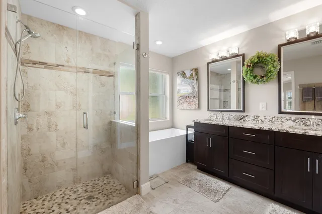 a bathroom with a granite countertop sink mirror and shower