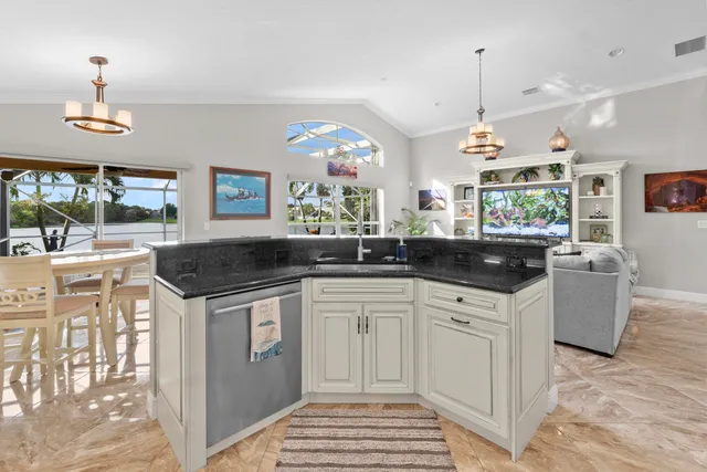 a kitchen with stainless steel appliances granite countertop a sink a stove and a wooden floors