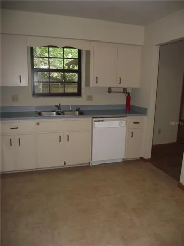 an empty room with windows and ceiling fan