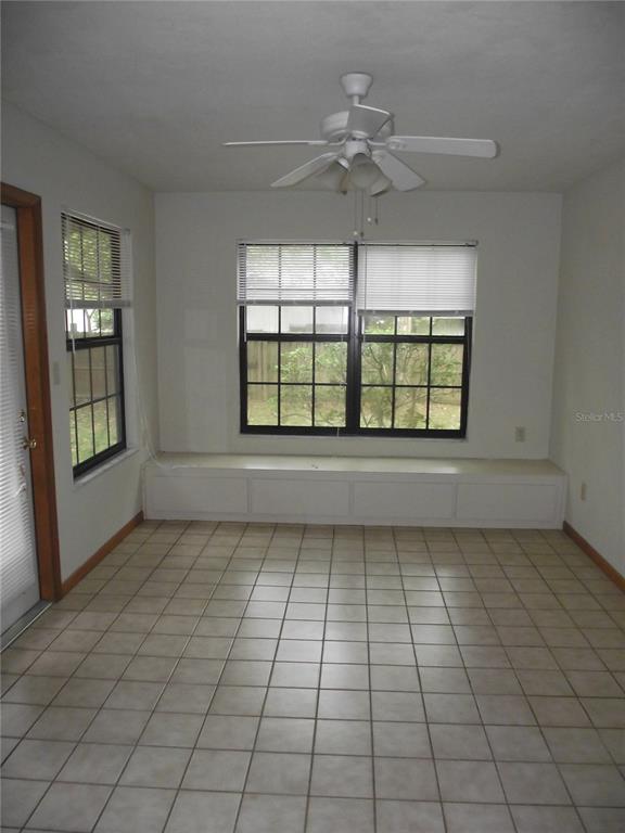 2624 Northwest 4th Avenue Gainesville, FL 32607 - Photo 12 of 14 an empty room with windows and ceiling fan