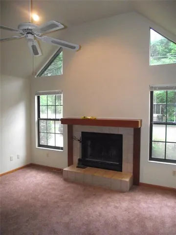 an empty room with windows and fireplace